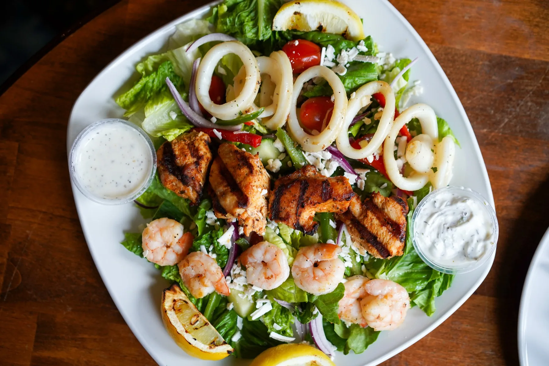 Tapas grill salad with chicken, shrimp, calamari, and lemon